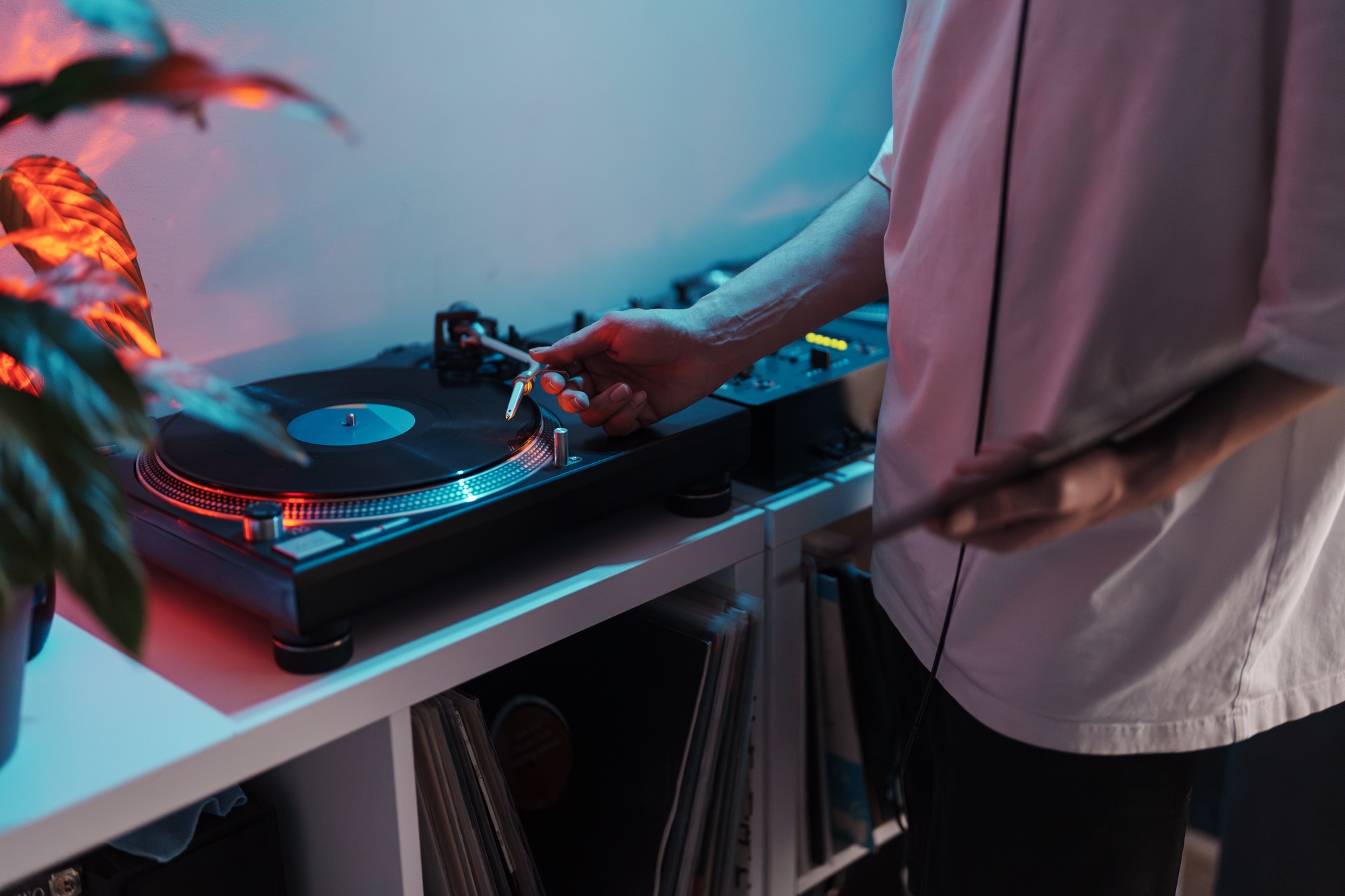 Dj mixing music on turntable in a home studio at night